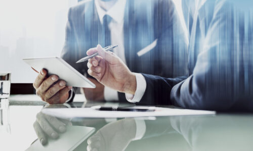 Corporate businessmen working on tablet at office